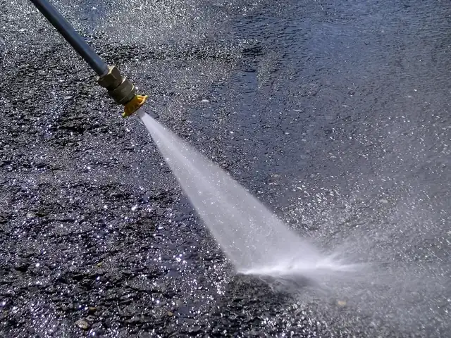 Pressure washing a dark tarmac surface
